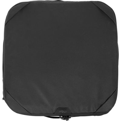 Black handheld Peak Design Camera Cube V2 with adjustable dividers, zipper closure, and durable nylon exterior, perfect for carrying camera gear safely.
