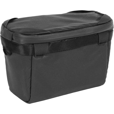 Black handheld Peak Design Camera Cube V2 with adjustable dividers, zipper closure, and durable nylon exterior, perfect for carrying camera gear safely.

