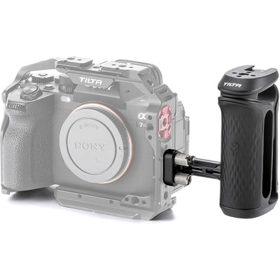 Tilta Xeno Side Handle with dual 1/4"-20 screw mount in black, featuring an ergonomic non-slip silicone grip and a cold shoe receiver for camera cage mounting.